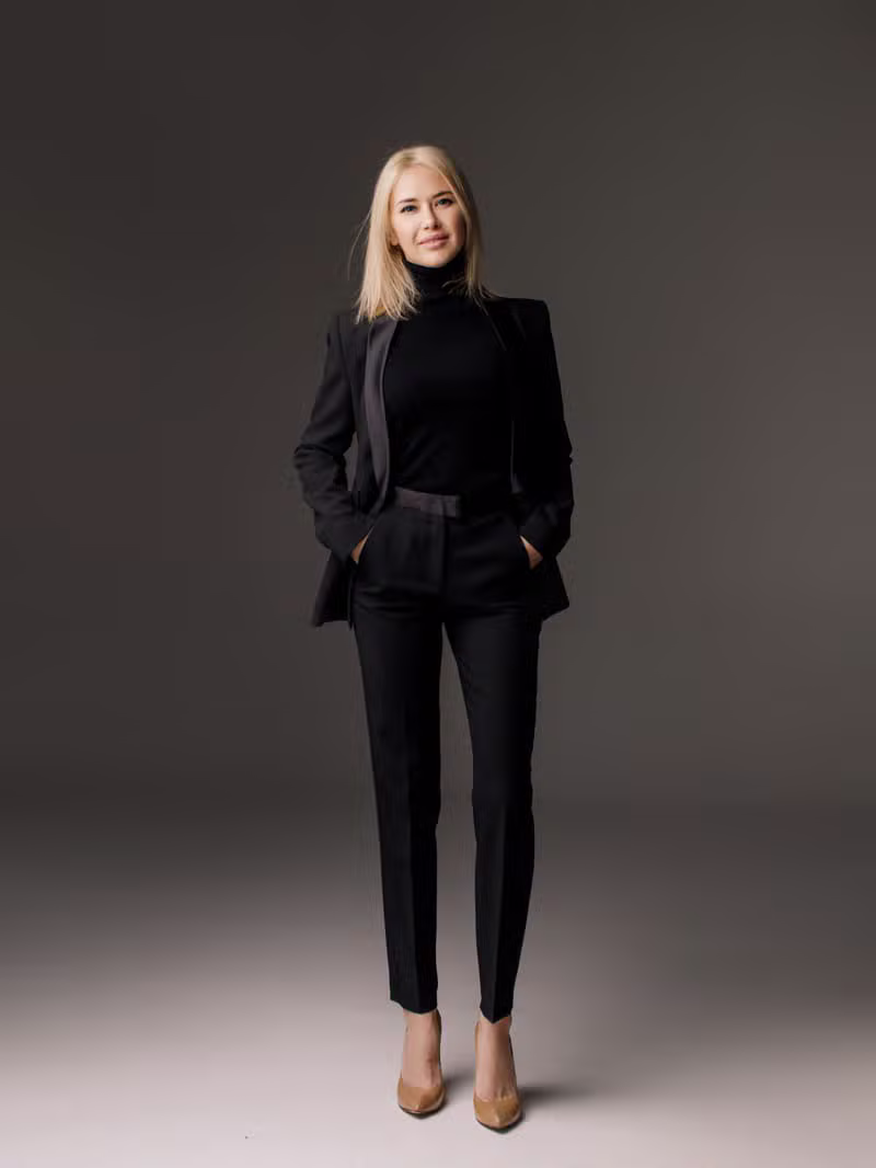 A bespoke tailored jacket on a woman in a minimal interior